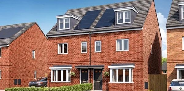 A modern brick duplex with solar panels on the roof under a clear sky.