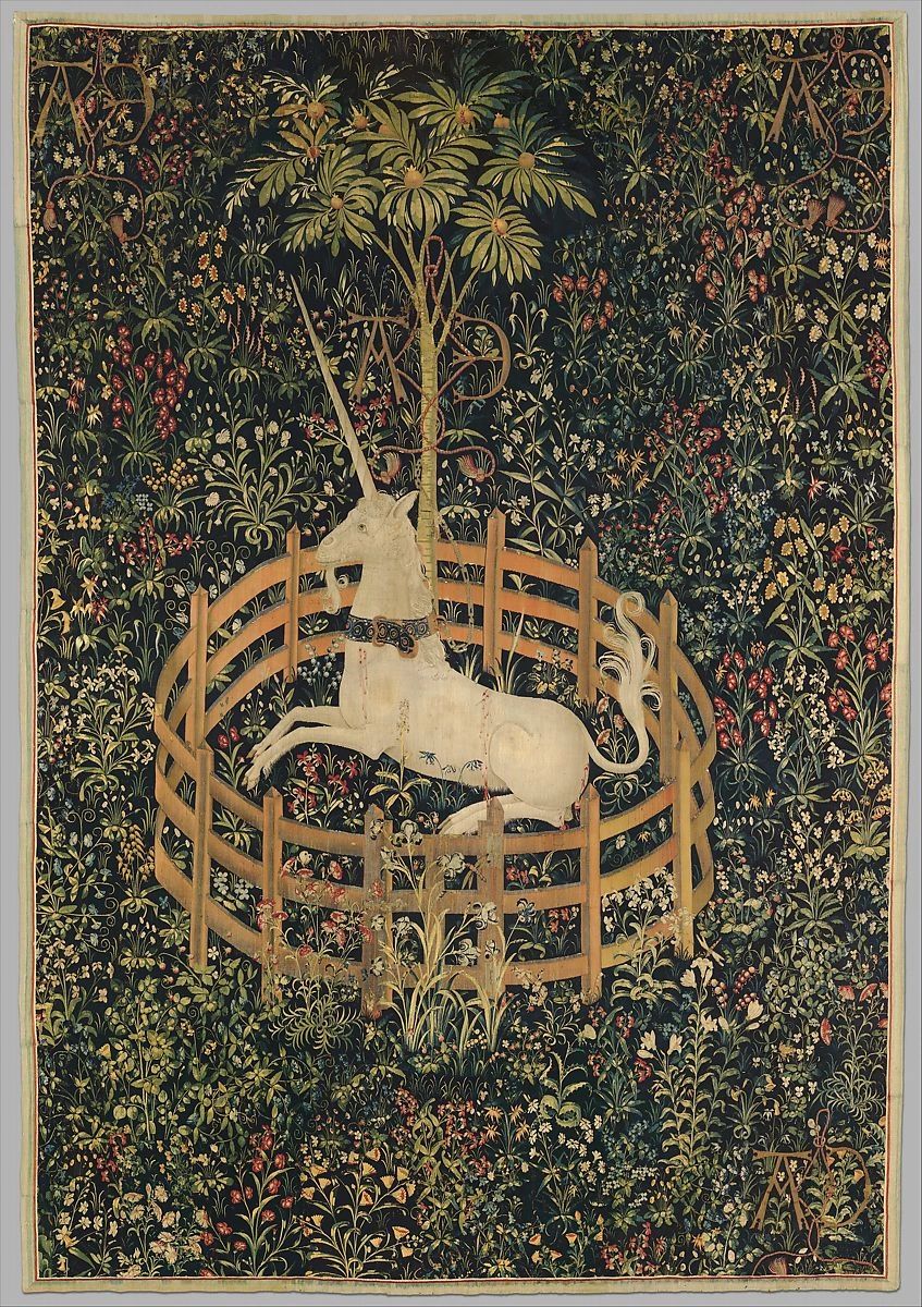 The unicorn rests in a garden.