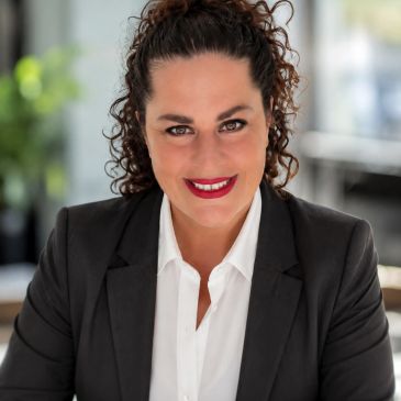 Professional woman in business attire smiling confidently.