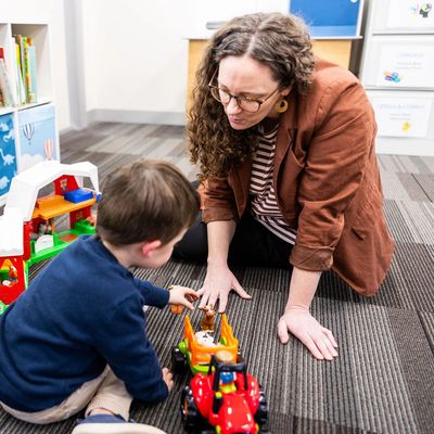 Young boy playing with farm set with his speech pathologist
