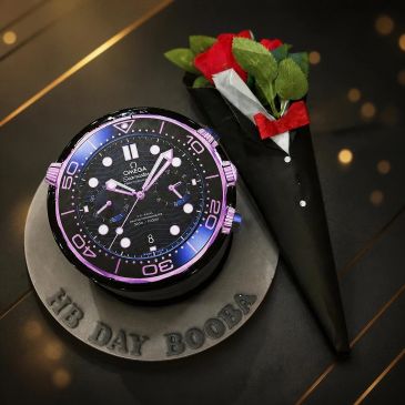 A watch-themed cake and a bouquet of red roses.
