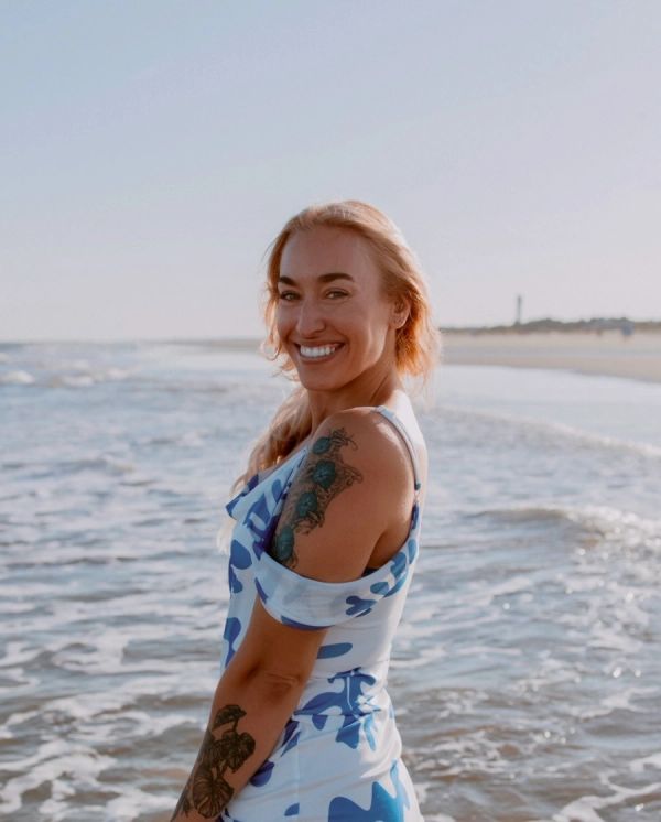Smiling woman with a tattoo at the beach.