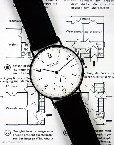 Bauhaus watch NOMOS Tangente 38 Date on Neufert "Bauentwurfslehre" construction book
