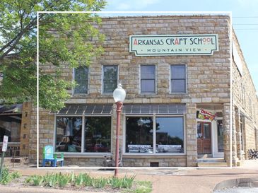 Historic Arkansas Craft School building with stone facade and large windows.