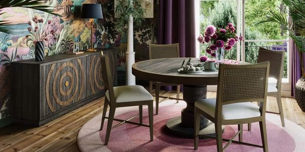 Cozy dining room with floral wallpaper and natural light through arched window.