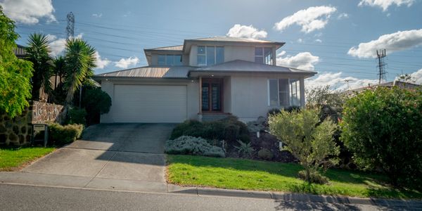 Modern two-story house with a driveway and well-kept garden.