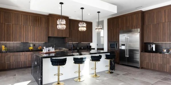 Modern kitchen with dark wood cabinets and black marble island.