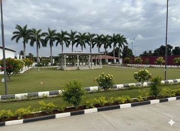 A landscaped garden with palm trees and a pavilion under a cloudy sky.