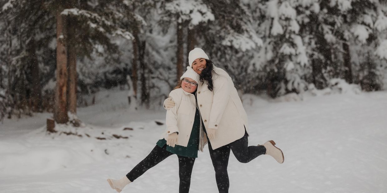 Two people hugging and posing in the snow.