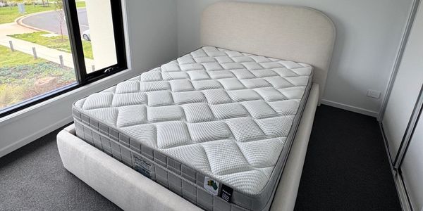 Modern bedroom with a neatly made bed and large window.