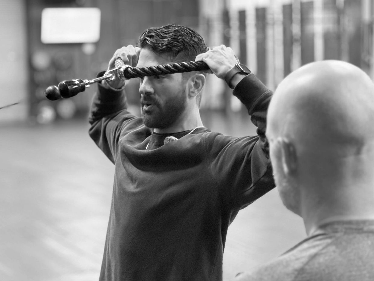 Eric demonstrating an exercise to a patient in a gym setting.