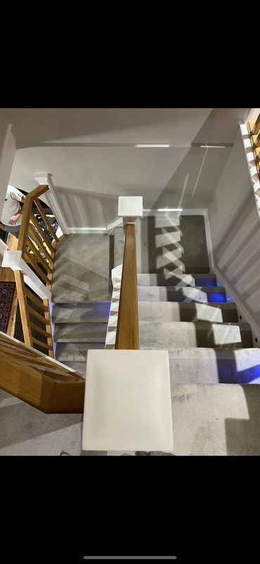 Professional staircase renovation featuring. Crisp white painted spindles, and a smooth varnished ha