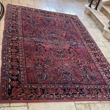 Traditional red Persian carpet on tiled floor.