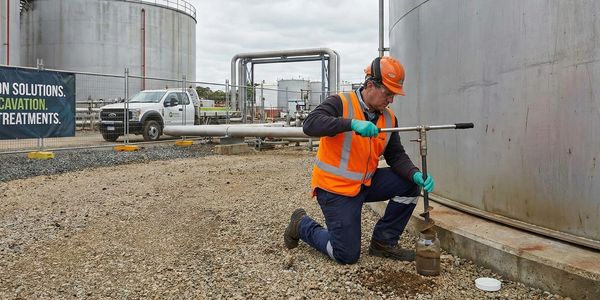 Field technician collecting soil samples to verify in-situ remediation results.
