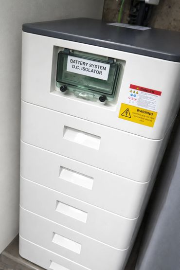 White battery system D.C. isolator unit with warning labels.