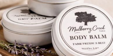 Tins of Mulberry Creek Farm body balm with lavender sprigs.