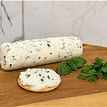 Herb-infused cream cheese log with crackers and fresh herbs on wooden board.