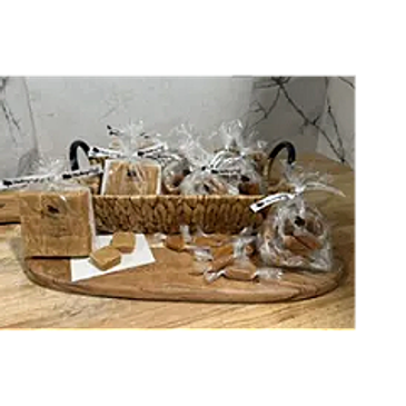 Assorted homemade baked goods wrapped in clear plastic on a wooden board.