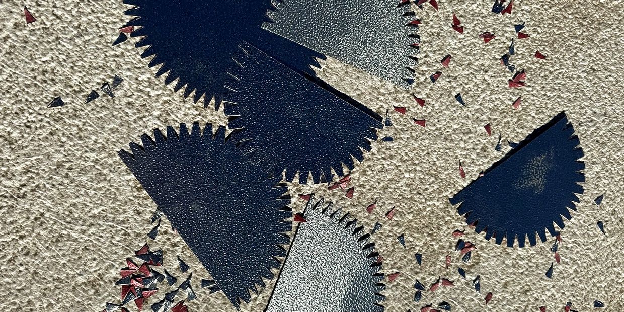 Close-up of textured, semi-circular torn pieces on a rough surface.
