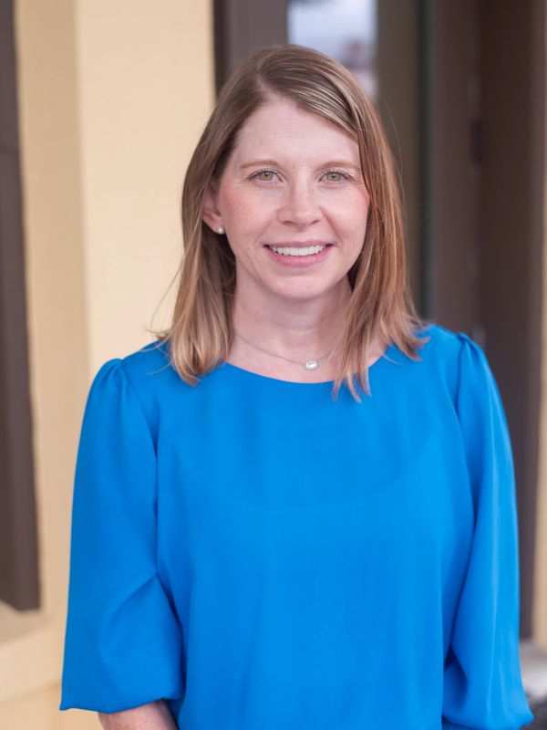 Smiling woman in a blue blouse.