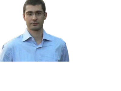 Man wearing glasses and a light blue shirt looking at the camera.