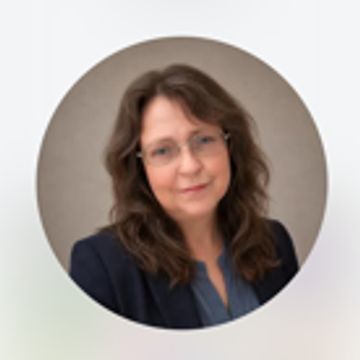 Professional portrait of a woman with glasses and brown hair.
