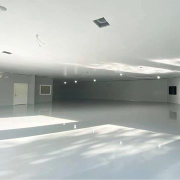 Empty, large white room with bright natural light.