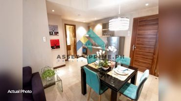 Cozy dining area with teal chairs and modern kitchen in a small apartment.