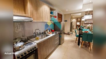Modern kitchen and dining area with turquoise chairs and stainless steel appliances.