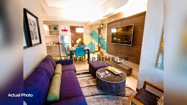 Cozy modern living room with purple sofa, round coffee table, and wall-mounted TV.