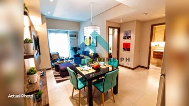 Modern dining and living area with teal chairs and cozy seating.