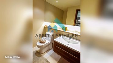 Modern bathroom with a toilet and wooden vanity sink.