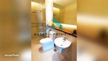 Modern bathroom with toilet, sink, and glass-enclosed shower area.