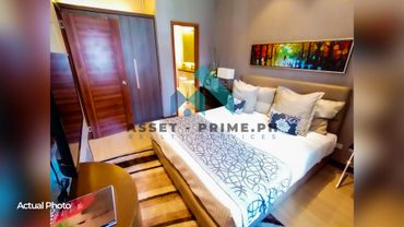 Cozy modern bedroom with a large bed, wooden wardrobe, and colorful painting above the headboard.