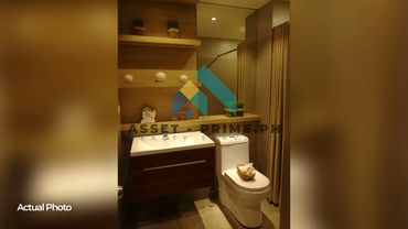 Modern bathroom with wooden shelves and warm lighting.