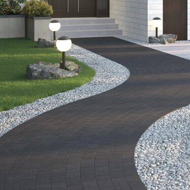 Dark-hued Permacon Capio paver walkway framed by white gravel edging In Toronto.