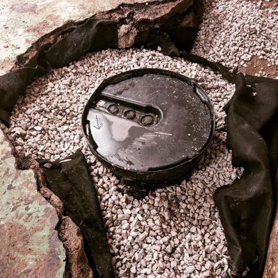 Interior sump pump basin set into gravel-filled trench with new weeping tile and protective liner