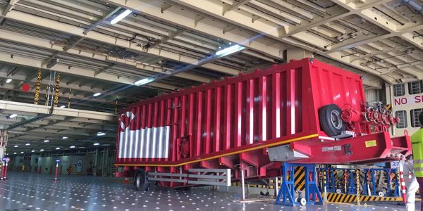 Large red cargo container inside a ship's hold.