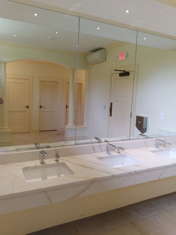 Finished commercial bathroom renovation with modern lighting and flooring