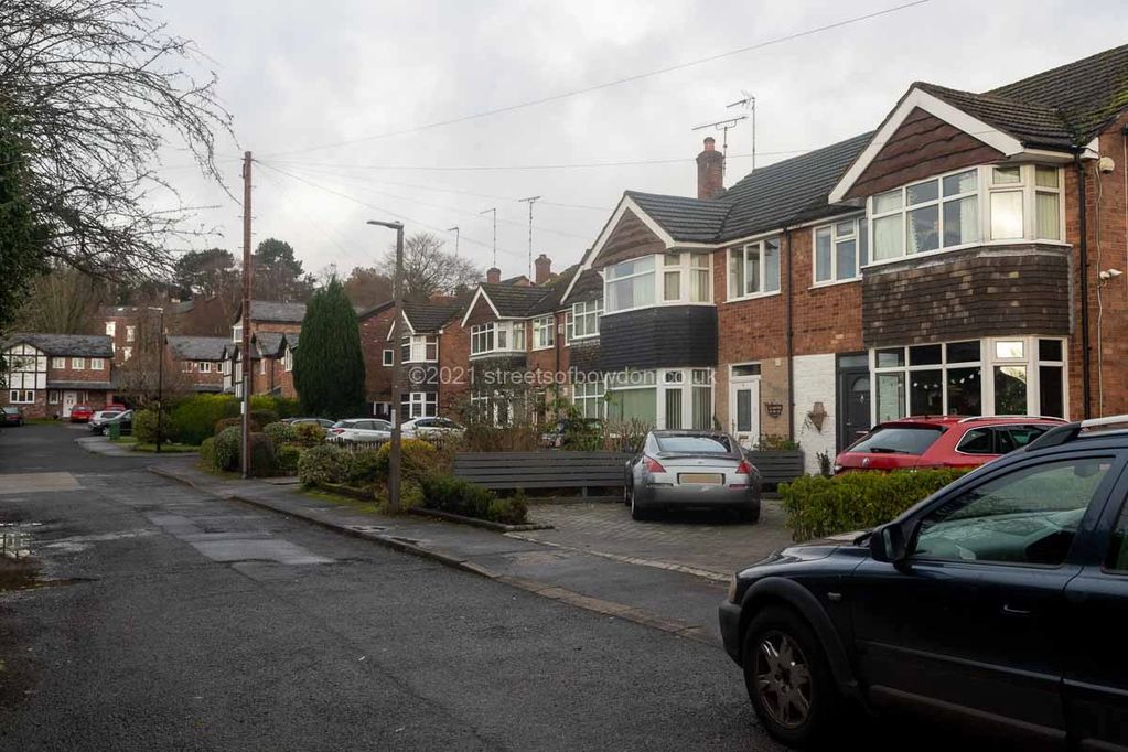 Street with 1930s semi-detached houses and more recent additions at far end