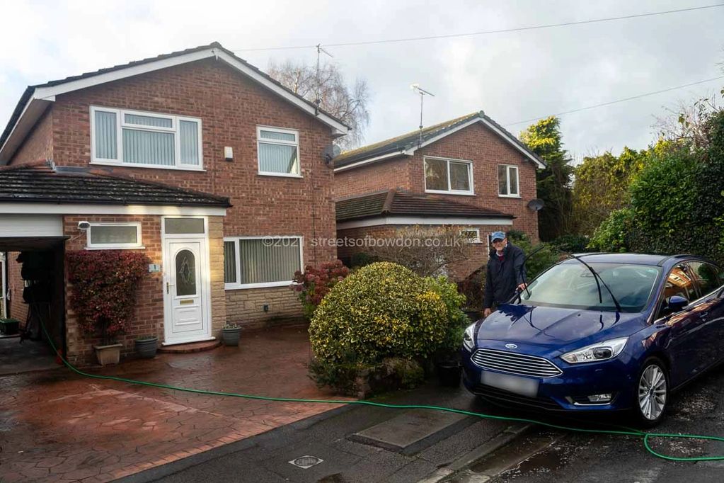 Man with car in front of house