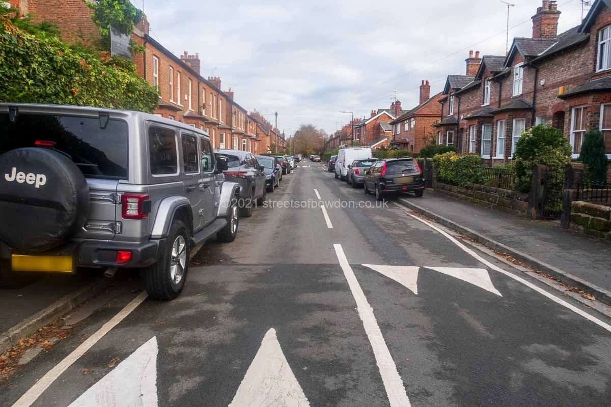 Vehicles parked on pavement on both sides of the road