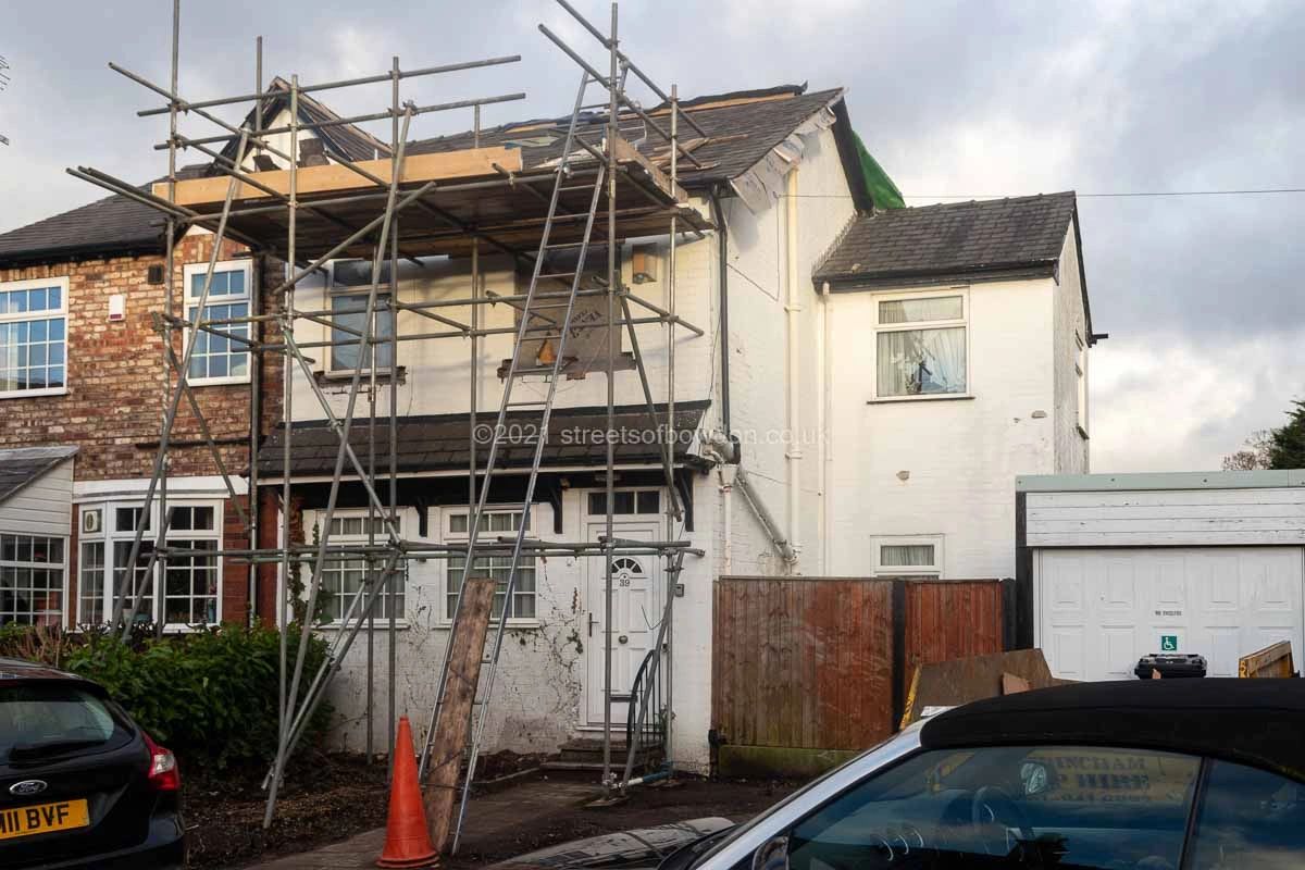 Small white house covered in scaffolding