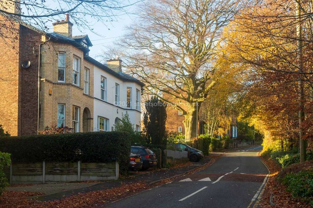 Autumnal scene of road with old houses on left