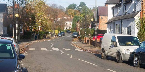 Suburban street with zebra crossing and parked cars