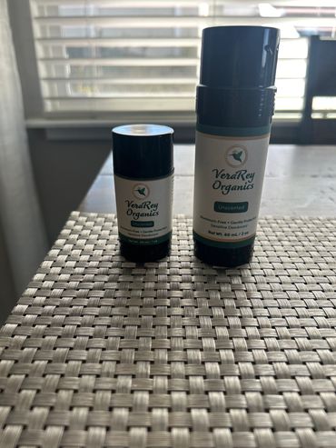 Two sizes of VeraRey Organics unscented deodorant on a woven mat.
