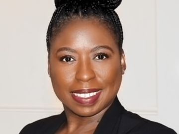 Professional woman with braided hair and a confident smile.