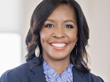 Professional woman smiling confidently in business attire.