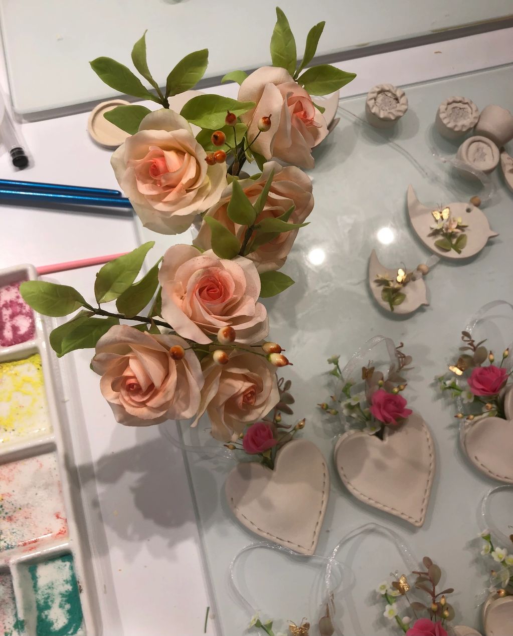 Delicate flowers and handmade decorations on a craft table.