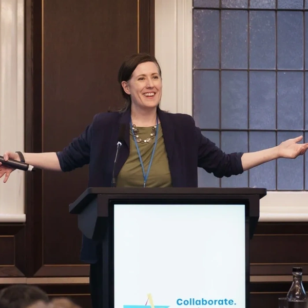 Katy standing at a podium leading an energising keynote session.